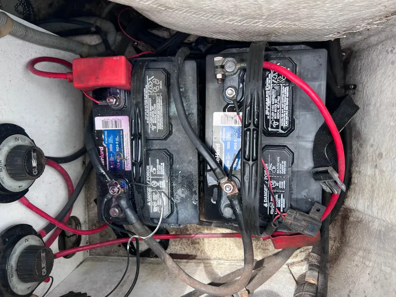 Slide: The Image of Boat battery compartment with wiring, featuring dual batteries in a 2006 Hurricane SunDeck 260 OB. - 18