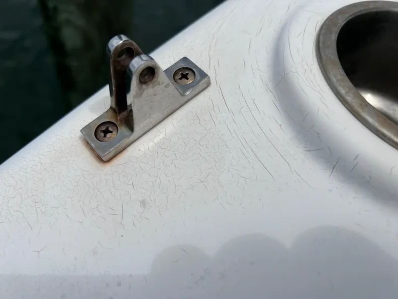 Slide: The Image of Close-up of a 2006 Hurricane SunDeck 260 OB boat's metal fitting on a white surface. - 19