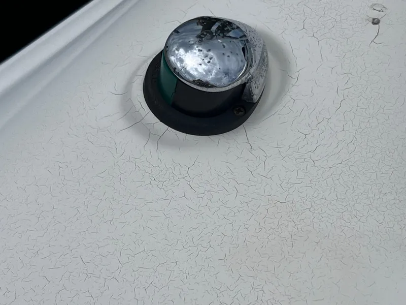 Slide: The Image of Navigation light on 2006 Hurricane SunDeck 260 OB boat with visible surface wear. - 22