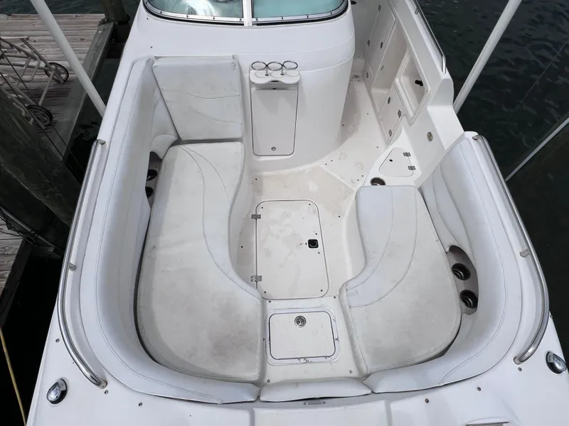 Slide: The Image of 2006 Hurricane SunDeck 260 OB boat interior with white seating and storage compartments. - 4