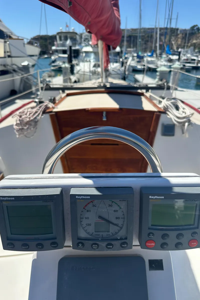 Slide: The Image of 1988 Catalina 30 sailboat cockpit with navigation instruments and marina view. - 15