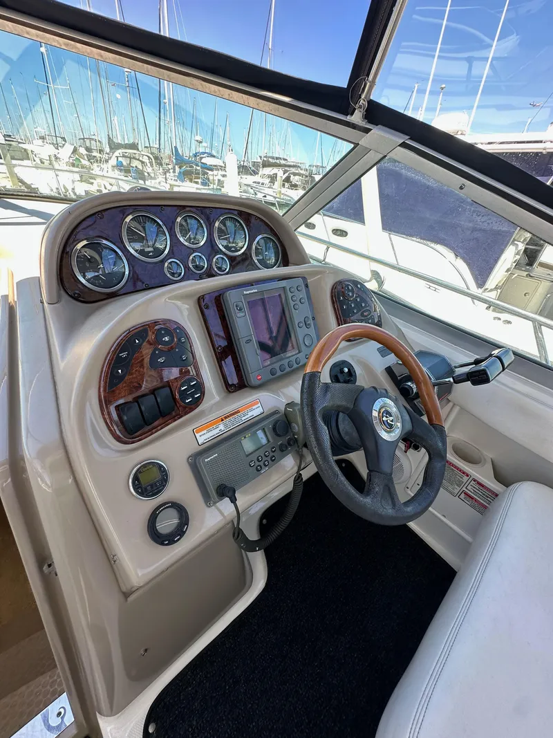 Slide: The Image of 2003 Sea Ray SUNDANCER 300 helm with gauges, steering wheel, and navigation equipment. - 14