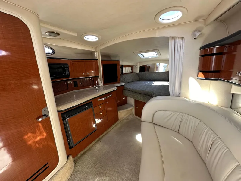 Slide: The Image of 2003 Sea Ray SUNDANCER 300 interior with wood cabinetry and cozy seating area. - 17