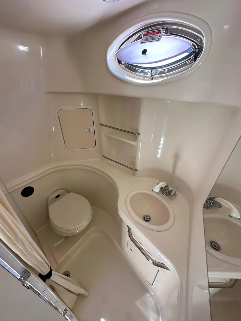 Slide: The Image of 2003 Sea Ray SUNDANCER 300 bathroom with toilet, sink, and porthole window. - 18