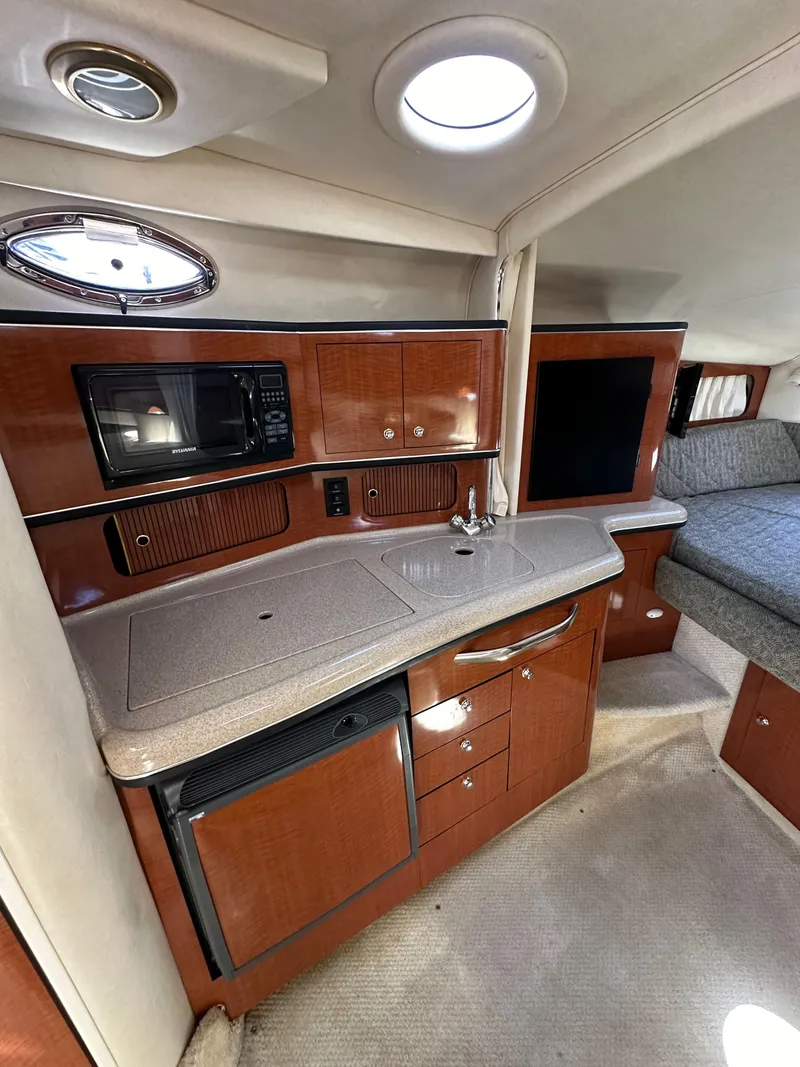 Slide: The Image of 2003 Sea Ray SUNDANCER 300 interior with kitchenette and seating area. - 19