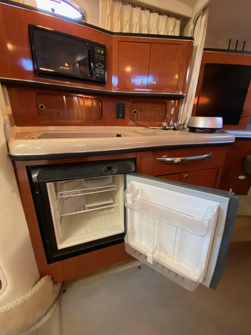 Slide: The Image of 2003 Sea Ray SUNDANCER 300 yacht kitchen with microwave and open fridge. - 20