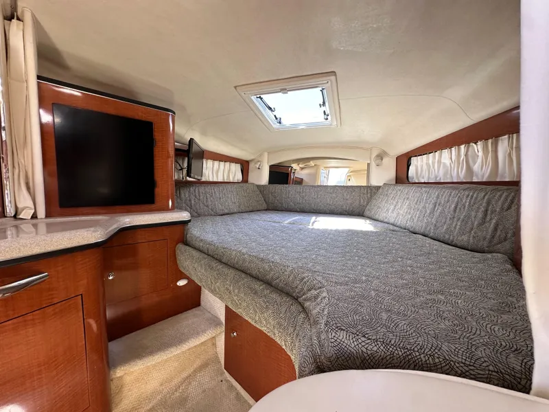 Slide: The Image of 2003 Sea Ray SUNDANCER 300 cabin interior with bed, TV, and skylight. - 23