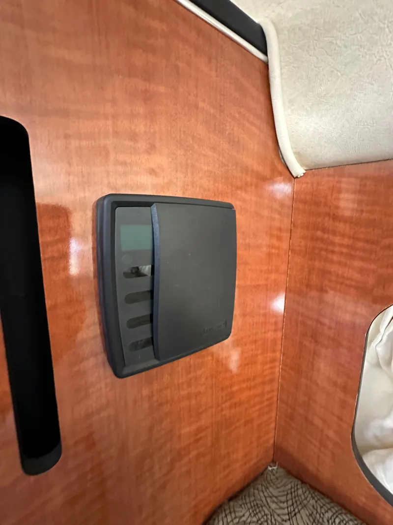 Slide: The Image of 2003 Sea Ray SUNDANCER 300 interior detail with wood paneling and control panel. - 24