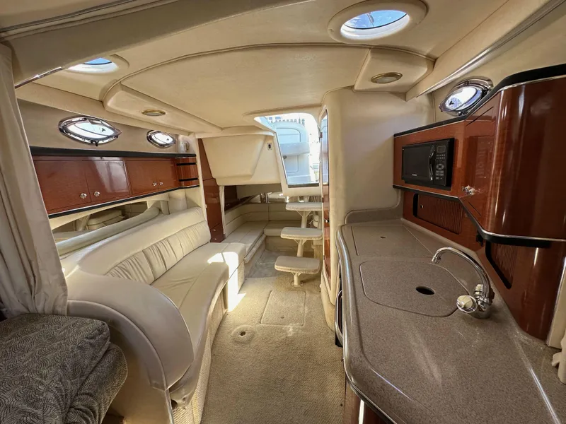 Slide: The Image of Interior of 2003 Sea Ray SUNDANCER 300 yacht with luxurious seating and kitchenette. - 27