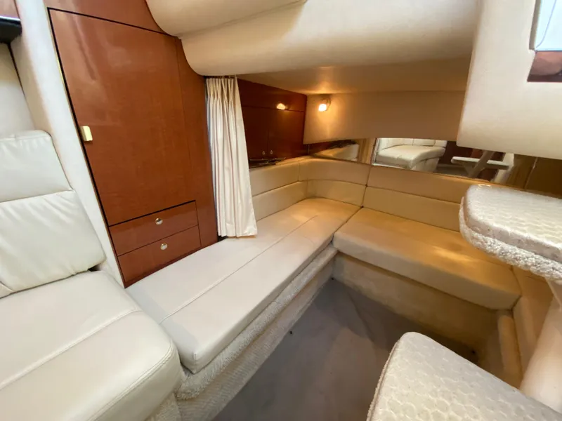 Slide: The Image of Interior of 2003 Sea Ray SUNDANCER 300, featuring beige seating and wooden cabinetry. - 30