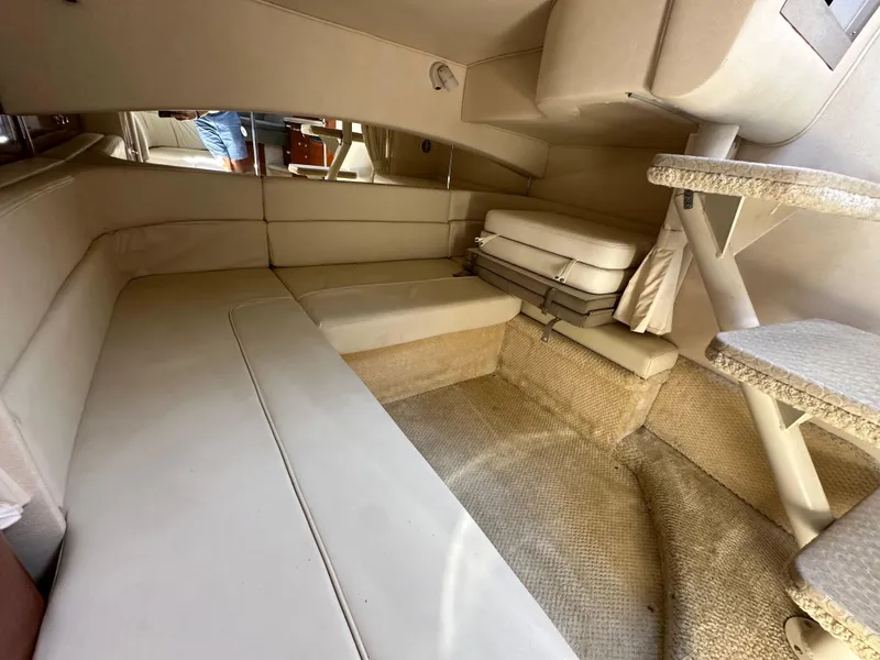 Slide: The Image of Interior of 2003 Sea Ray SUNDANCER 300, featuring beige seating and carpeted steps. - 31