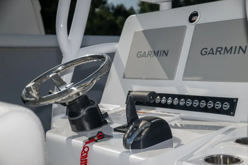 Slide: The Image of 2025 Contender 26 Bay boat dashboard with Garmin displays and steering wheel. - 14