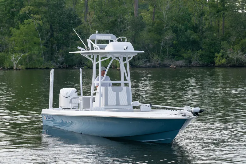 Slide: The Image of 2025 Contender 26 Bay boat on calm water, surrounded by lush greenery. - 18