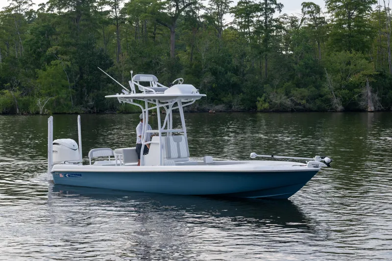 Slide: The Image of 2025 Contender 26 Bay boat on calm water with lush forest background. - 19