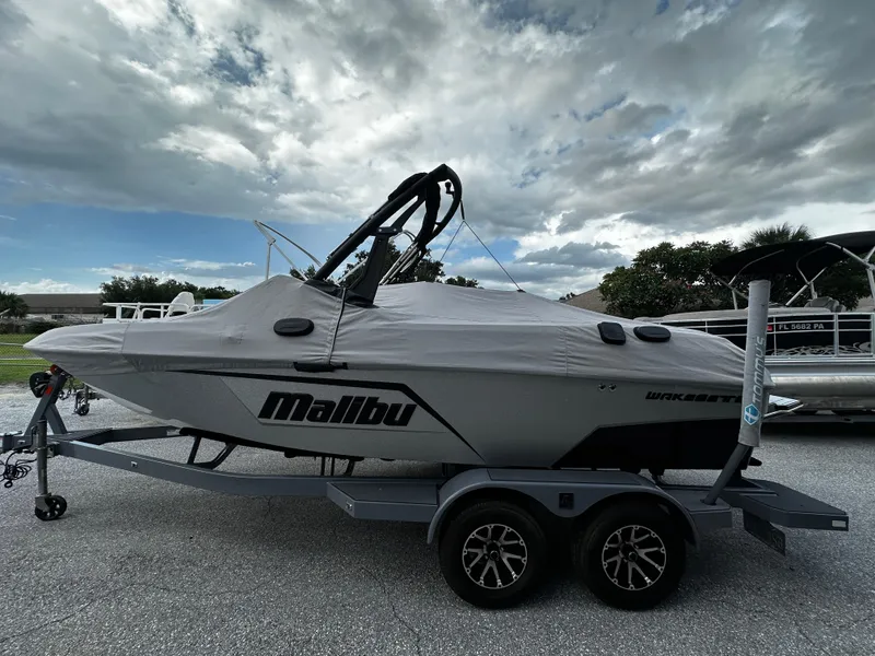 Slide: The Image of 2022 Malibu Wakesetter 20 VTX boat on trailer under cloudy sky. - 1
