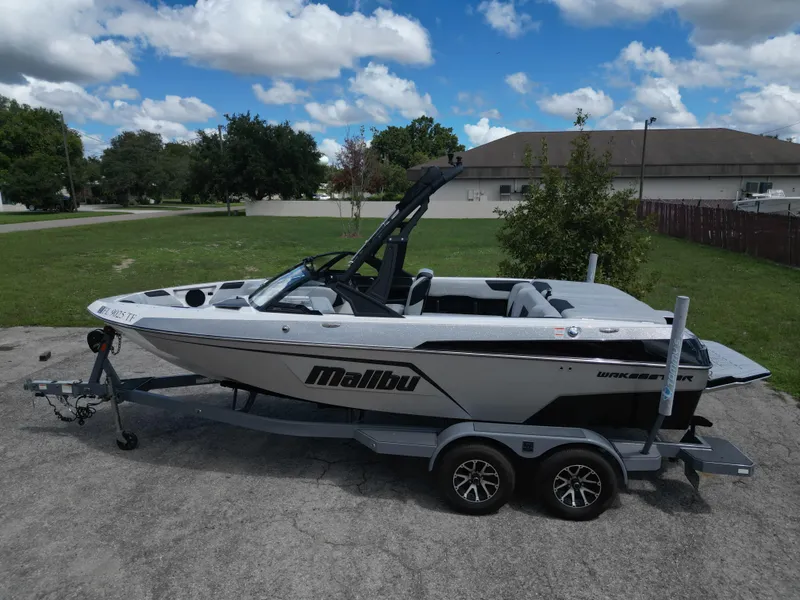 Slide: The Image of 2022 Malibu Wakesetter 20 VTX boat on trailer, parked outdoors under blue sky. - 11
