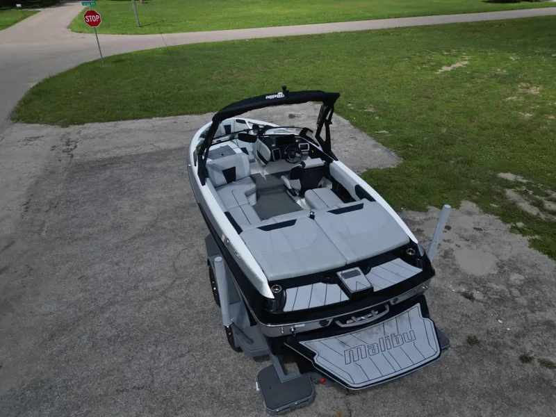 Slide: The Image of 2022 Malibu Wakesetter 20 VTX boat on pavement, surrounded by grass and a stop sign. - 4