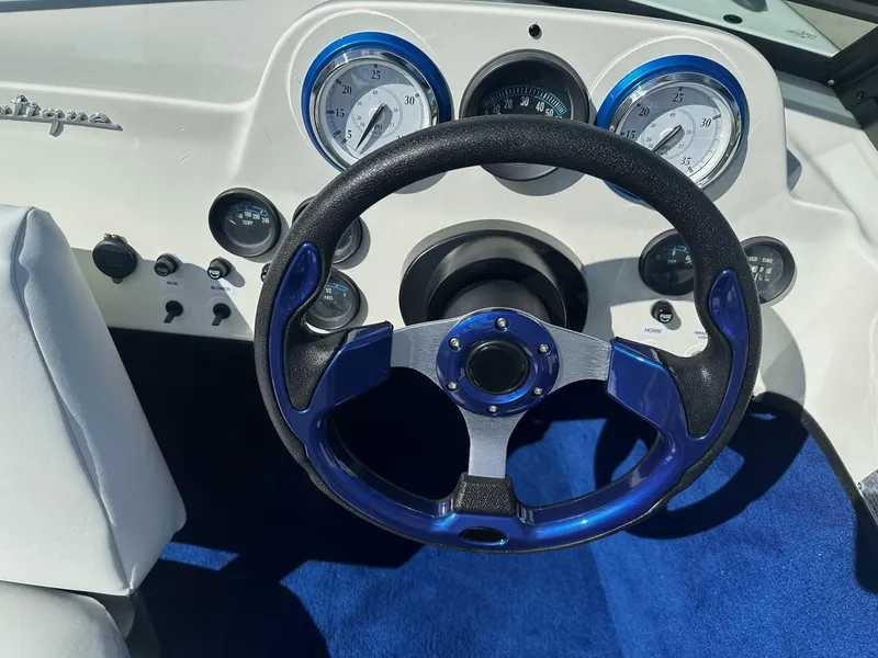 Slide: The Image of 1977 Correct Craft Ski Nautique dashboard with blue steering wheel and gauges. - 17