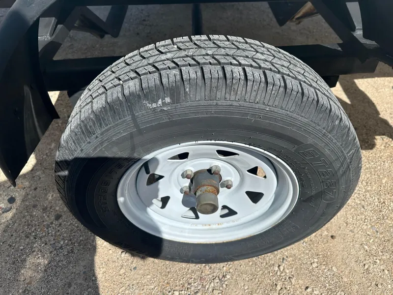 Slide: The Image of 1977 Correct Craft Ski Nautique trailer tire on gravel surface. - 23