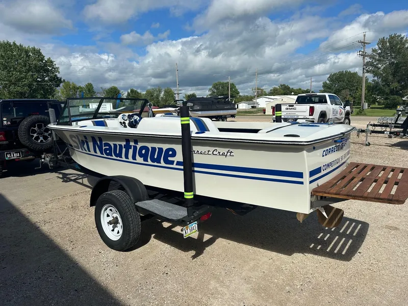 Slide: The Image of 1977 Correct Craft Ski Nautique boat on trailer, parked outdoors under cloudy sky. - 7
