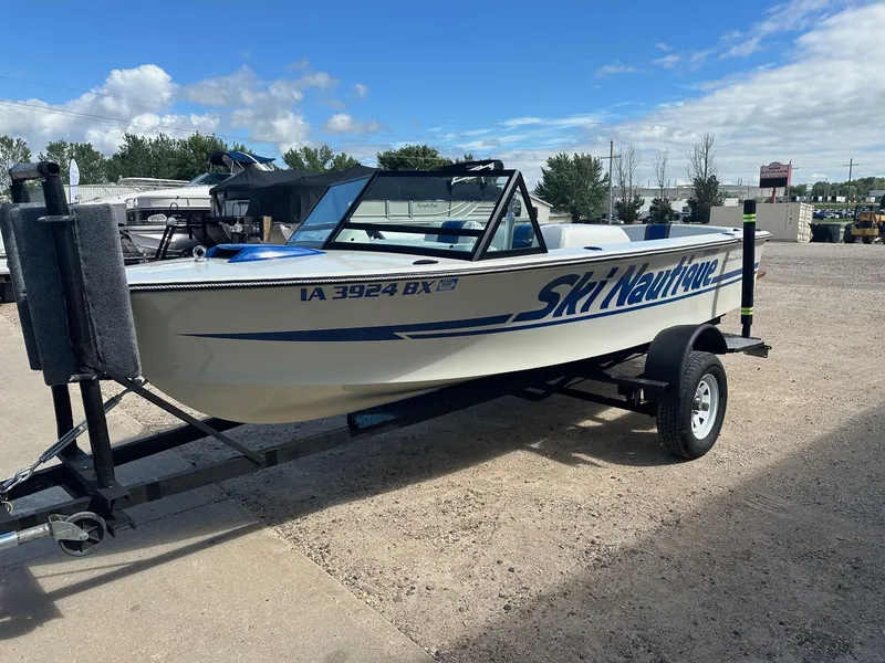 Slide: The Image of 1977 Correct Craft Ski Nautique boat on trailer, parked outdoors under blue sky. - 9