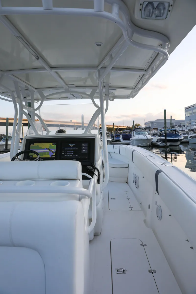 Slide: The Image of 2008 Midnight Express 37 boat interior at marina, featuring sleek white design and modern navigation system. - 19