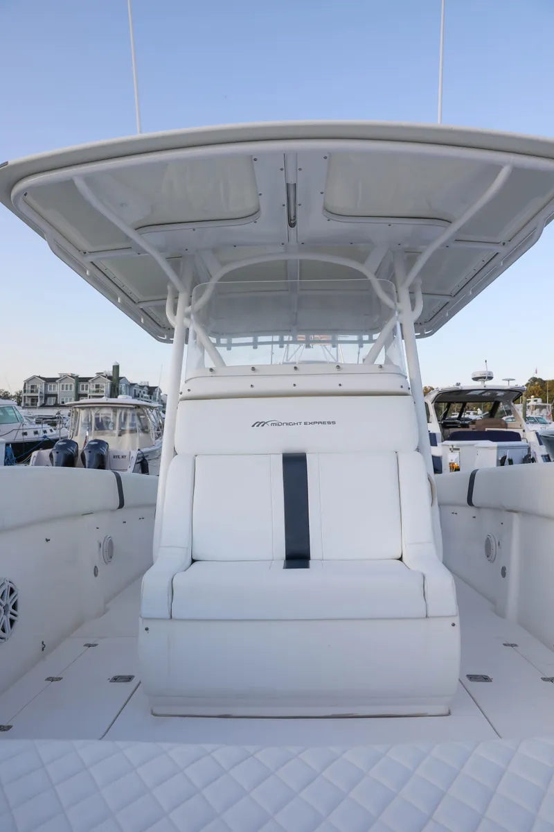 Slide: The Image of 2008 Midnight Express 37 boat with white seating and canopy at a marina. - 22