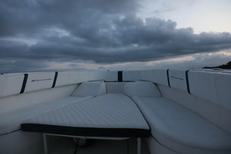 Slide: The Image of 2008 Midnight Express 37 boat interior with cushioned seating under cloudy sky. - 29