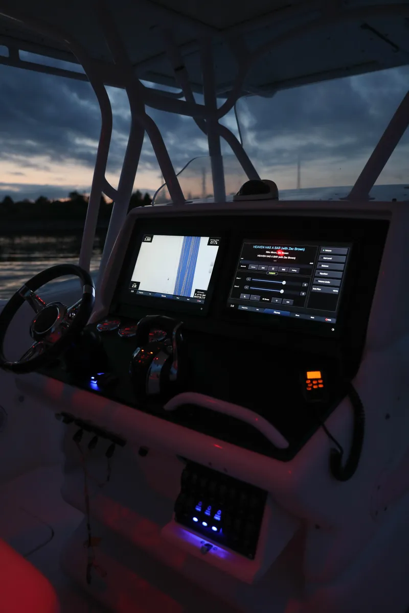 Slide: The Image of 2008 Midnight Express 37 boat dashboard with illuminated navigation screens at dusk. - 34