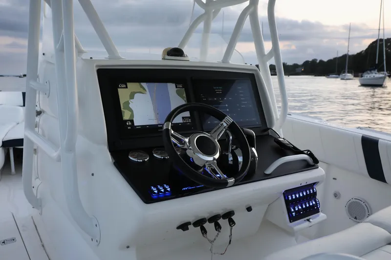 Slide: The Image of 2008 Midnight Express 37 boat dashboard with navigation screens and controls at sunset. - 6