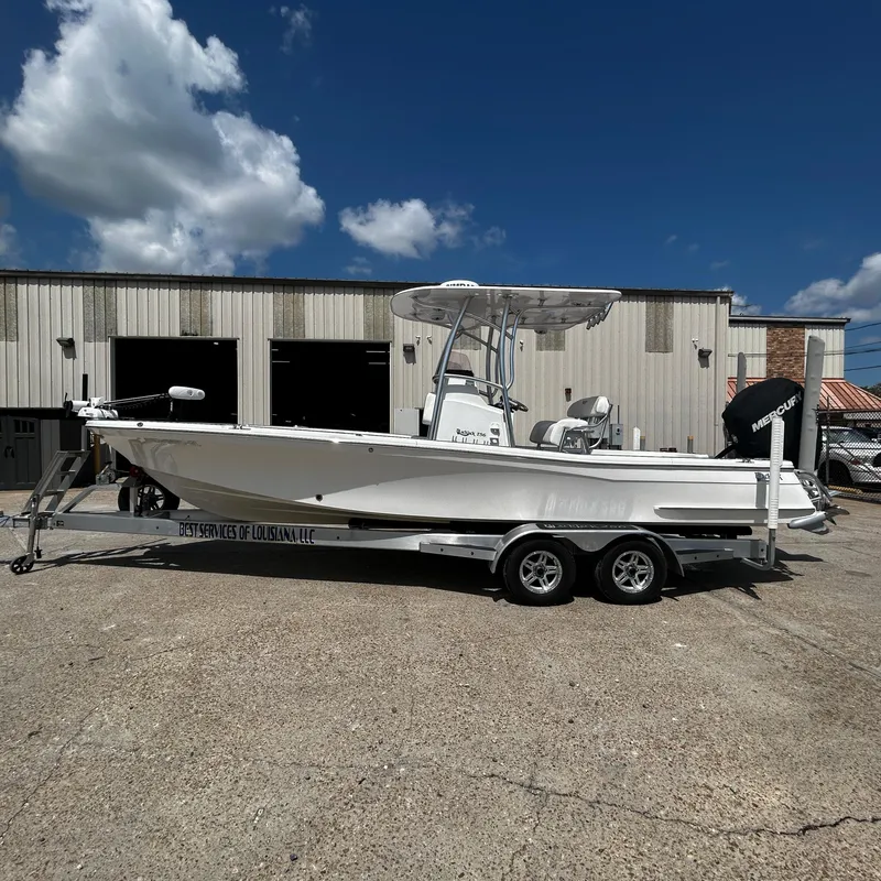 Slide: The Image of 2021 BlackJack 256 Bay boat on trailer, parked outside a warehouse. - 0