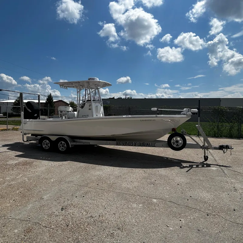 Slide: The Image of 2021 BlackJack 256 Bay boat on trailer under a partly cloudy sky. - 1