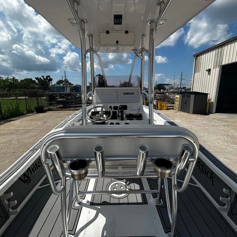 Slide: The Image of 2021 BlackJack 256 Bay boat interior with steering console and rod holders. - 14