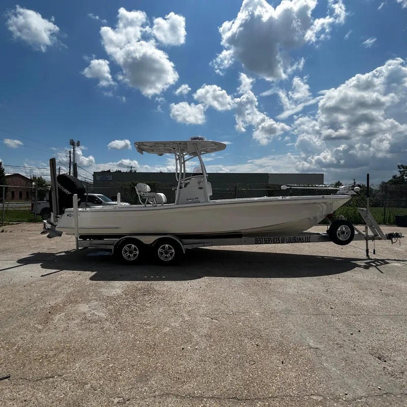 Slide: The Image of 2021 BlackJack 256 Bay boat on trailer under a partly cloudy sky. - 2