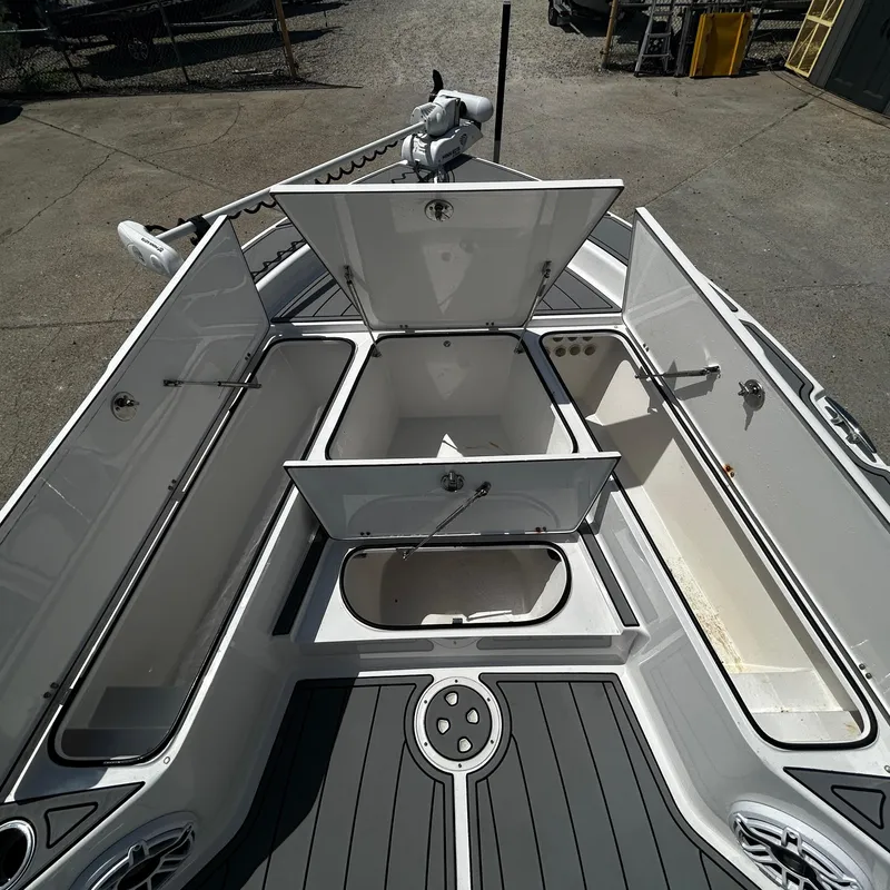 Slide: The Image of 2021 BlackJack 256 Bay boat with open storage compartments on deck. - 21