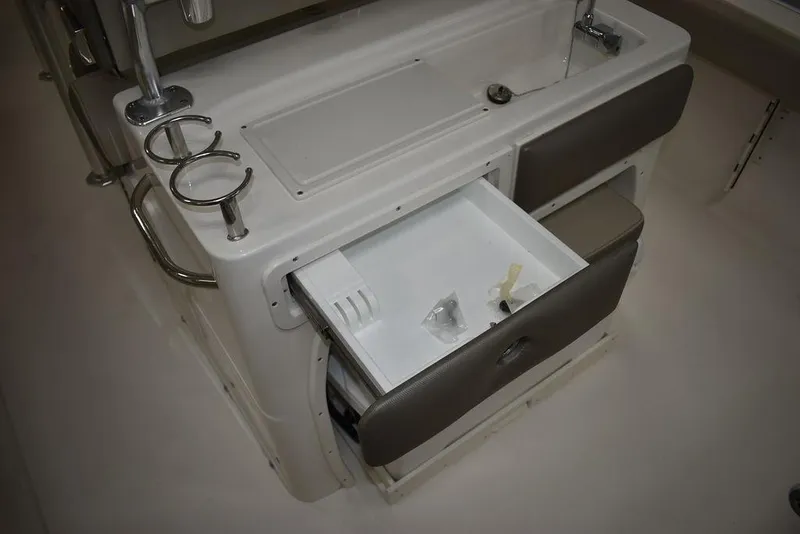 Slide: The Image of 2024 Key West 239 FS boat interior with open storage compartment and cup holders. - 16