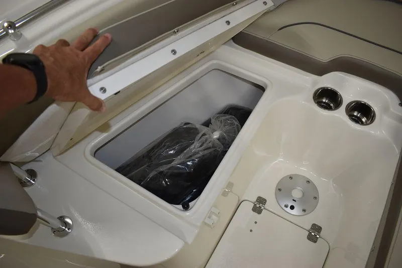 Slide: The Image of 2024 Key West 239 FS boat storage compartment with cup holders and hand opening lid. - 23