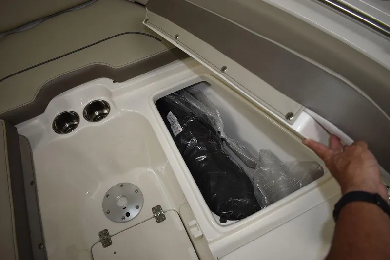 Slide: The Image of 2024 Key West 239 FS boat storage compartment with cup holders and hand opening lid. - 24