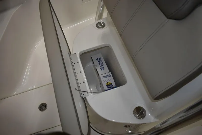 Slide: The Image of 2024 Key West 239 FS boat seat storage compartment with a box inside. - 27