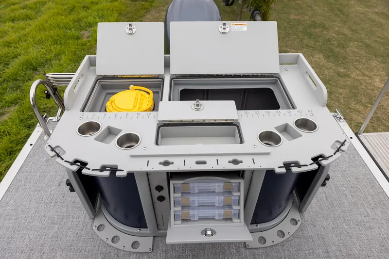 Slide: The Image of 2025 Premier 230 SunSation Angler fishing station with storage compartments and cup holders. - 11