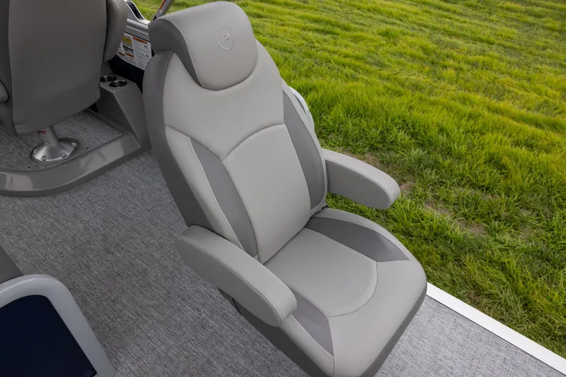 Slide: The Image of 2025 Premier 230 SunSation Angler boat seat, gray upholstery, on deck with grass background. - 14