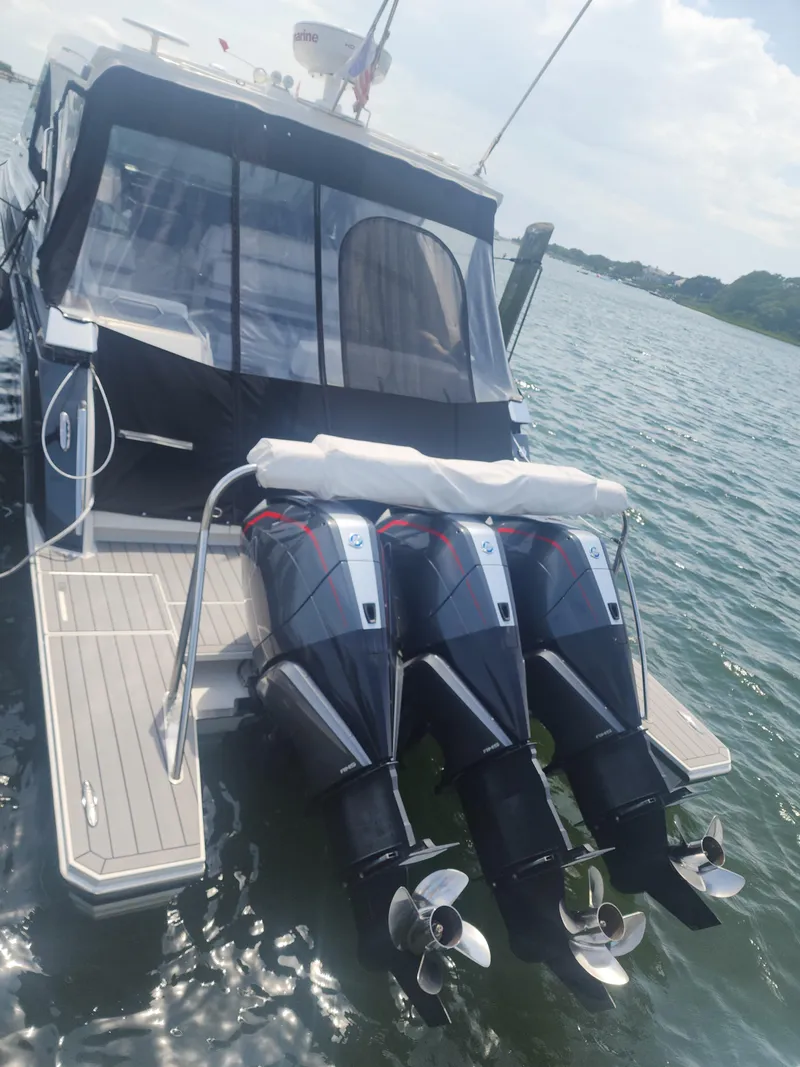 Slide: The Image of 2021 Formula 380 Super Sport Crossover OB with triple outboard engines docked on water. - 25