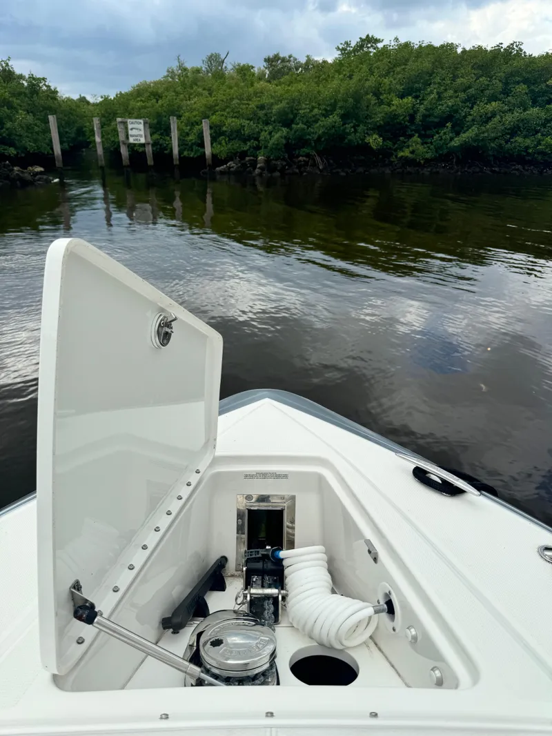 Slide: The Image of 2021 Formula 380 Super Sport Crossover OB boat with open storage compartment on calm water. - 8