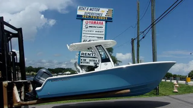 Slide: The Image of 2025 Sportsman Open 212 boat displayed at dealership with signage in background. - 1