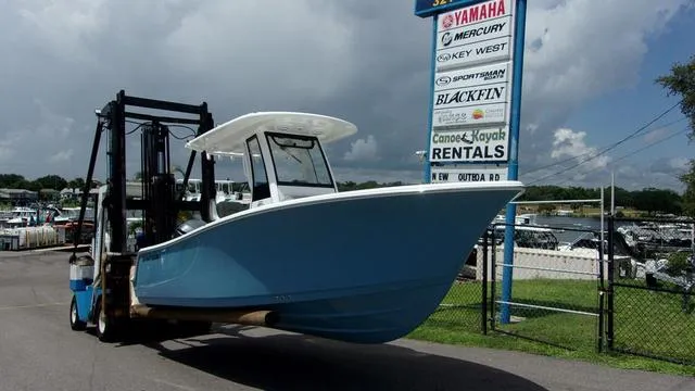 Slide: The Image of 2025 Sportsman Open 212 boat on forklift near rental sign. - 2