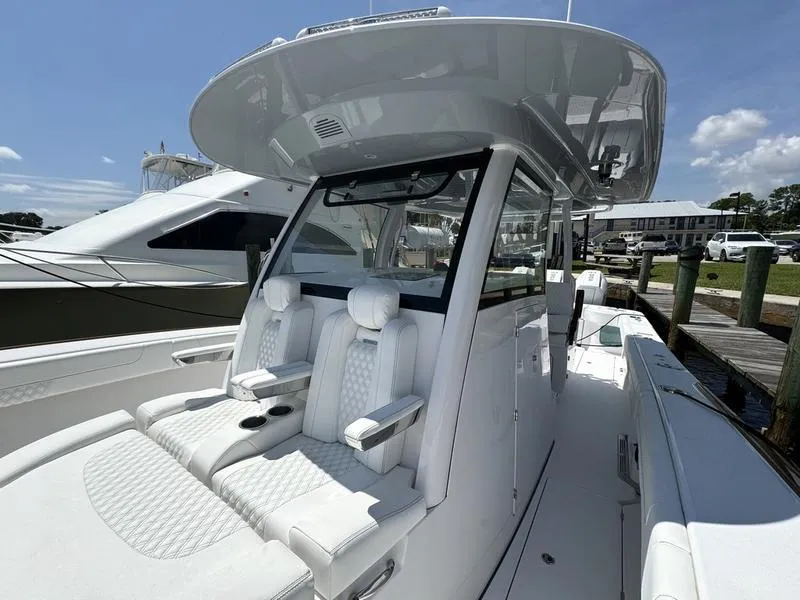 Slide: The Image of 2025 Phenom 37 boat with sleek white seating and modern design at a marina. - 14