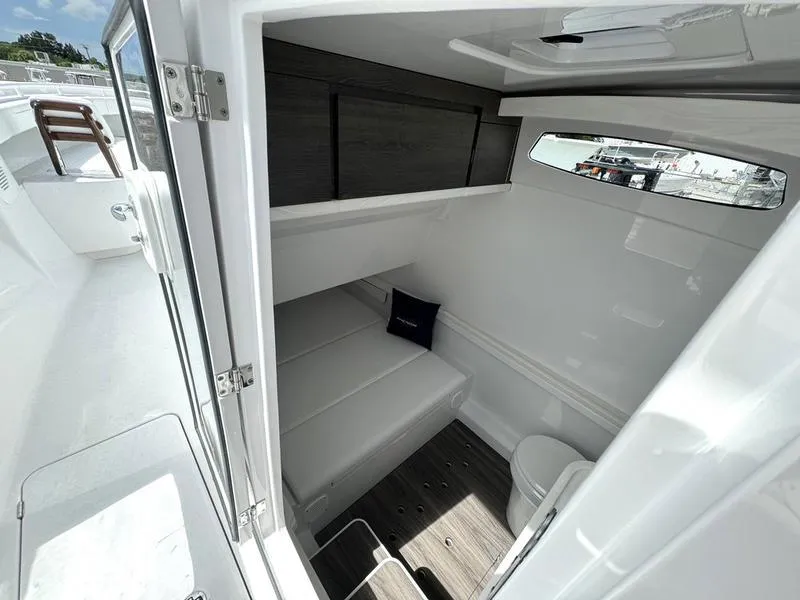 Slide: The Image of Interior cabin of 2025 Phenom 37 boat, featuring sleek white design and compact layout. - 19