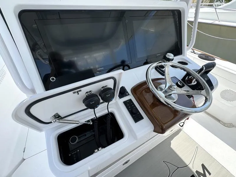 Slide: The Image of Phenom 37 boat dashboard with steering wheel and electronic controls, 2025 model. - 35