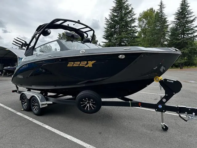Slide: The Image of 2025 Yamaha Boats 222XD on trailer, sleek black design, parked outdoors. - 3