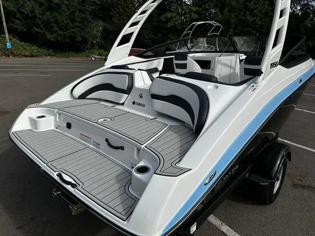 Slide: The Image of 2025 Yamaha Boats 195S, sleek design, spacious seating, parked outdoors. - 12